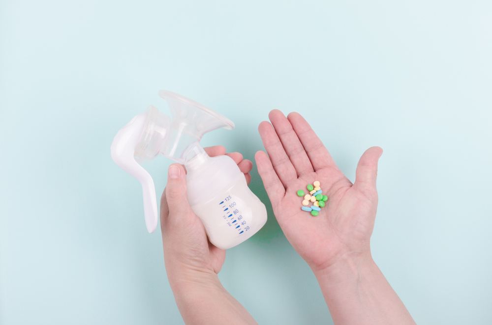 Two,Hands,With,Breast,Pump,And,Drugs,On,Blue,Background.