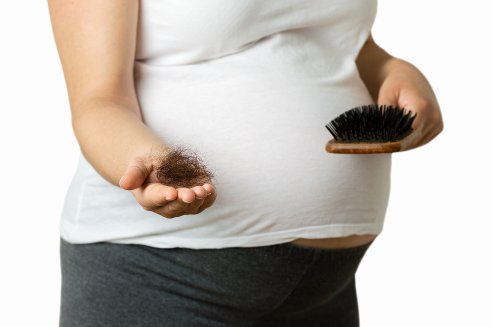 Pregnant,Woman,Hand,Palm,Holding,A,Hairs,And,A,Comb