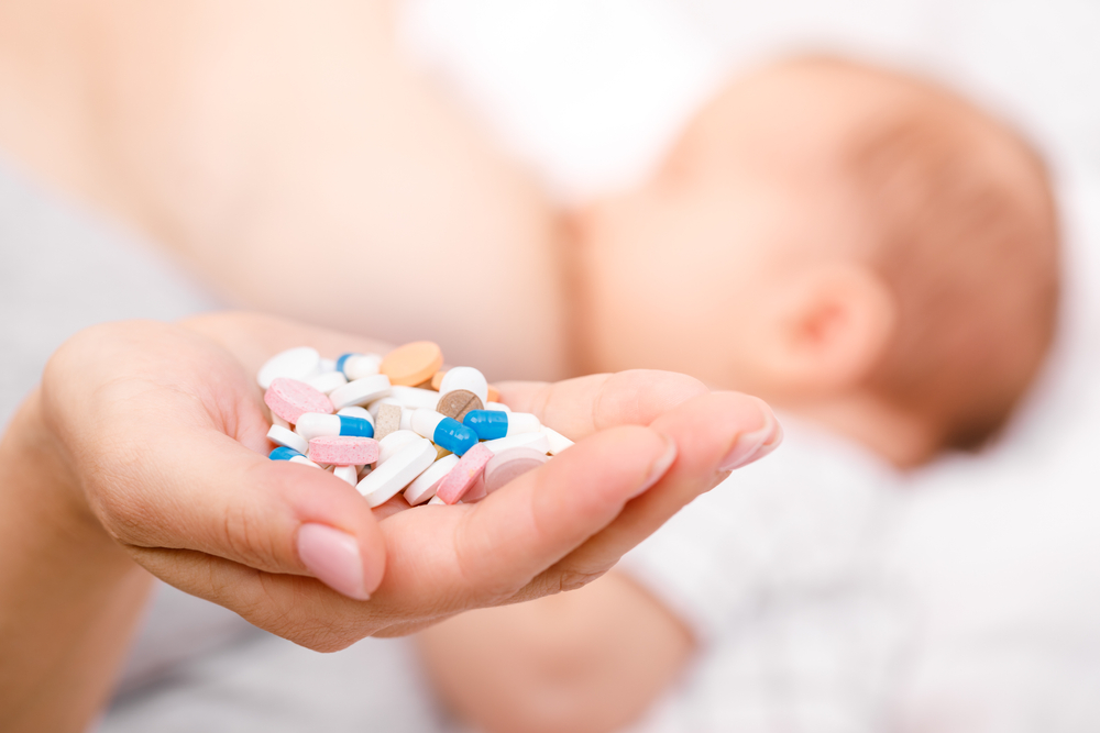 Mother,Holding,Handful,Of,Pills,And,Tablets,While,Breastfeeding,Newborn